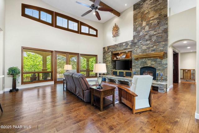 2469 W Post Oak Dr, Prescott, AZ 86305 - living room with a high ceiling, ceiling fan, hardwood / wood-style floors, a stone fireplace, and arched walkways