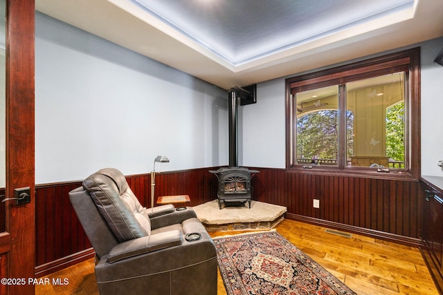 2469 W Post Oak Dr, Prescott, AZ 86305 - sitting room featuring a wood stove, a wainscoted wall, wooden walls, and wood finished floors