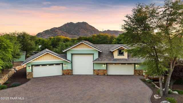 2469 W Post Oak Dr, Prescott, AZ 86305 - view of front facade featuring stone siding, a mountain view, an attached garage, and decorative driveway
