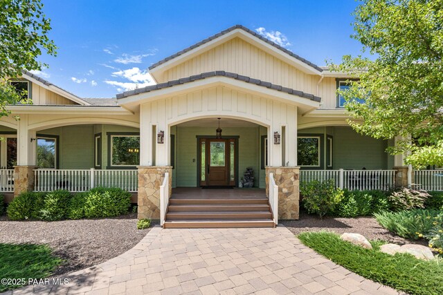 2469 W Post Oak Dr, Prescott, AZ 86305 - view of exterior entry with a porch, board and batten siding, and stone siding