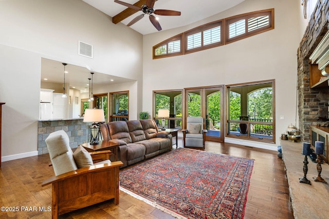 2469 W Post Oak Dr, Prescott, AZ 86305 - living room with a ceiling fan, a towering ceiling, a stone fireplace, and wood-type flooring