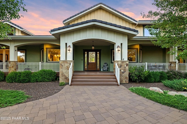 2469 W Post Oak Dr, Prescott, AZ 86305 - exterior entry at dusk with covered porch, board and batten siding, and stone siding