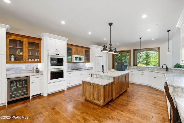 2469 W Post Oak Dr, Prescott, AZ 86305 - kitchen with wine cooler, white appliances, decorative backsplash, light wood finished floors, and recessed lighting