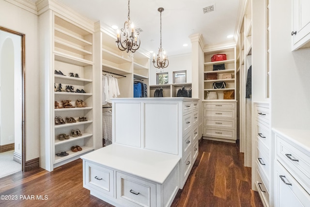 walk in closet featuring dark hardwood / wood-style flooring and a notable chandelier