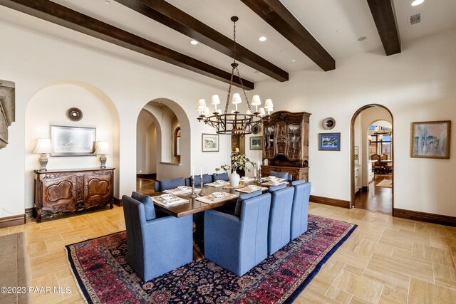 dining area featuring beam ceiling and a chandelier