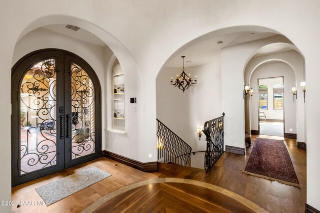 entryway featuring a chandelier, wood-type flooring, and french doors