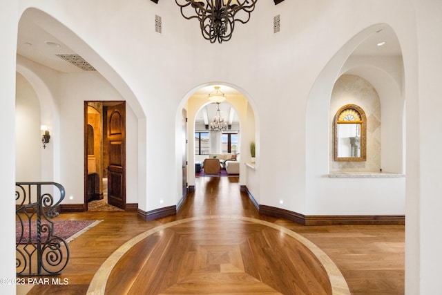 entrance foyer featuring a notable chandelier, dark hardwood / wood-style flooring, and a high ceiling