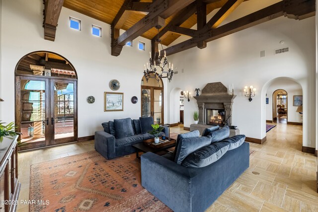 living room with beam ceiling, high vaulted ceiling, and french doors