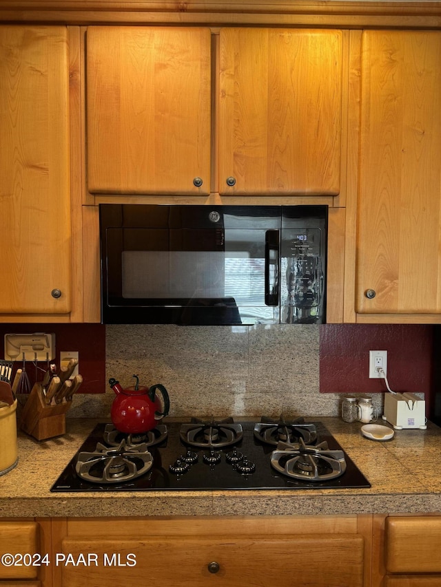 kitchen featuring decorative backsplash and black appliances