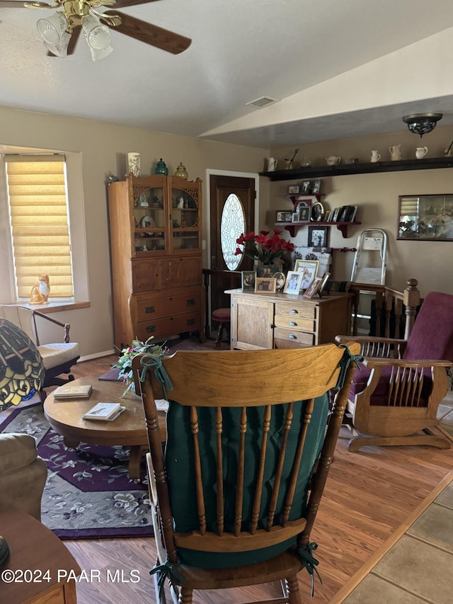 living room featuring ceiling fan, wood-type flooring, and lofted ceiling