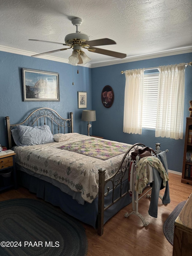 bedroom featuring hardwood / wood-style flooring, ceiling fan, a textured ceiling, and ornamental molding