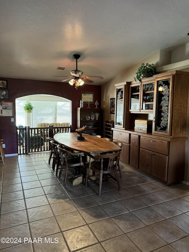 dining space featuring ceiling fan and a textured ceiling