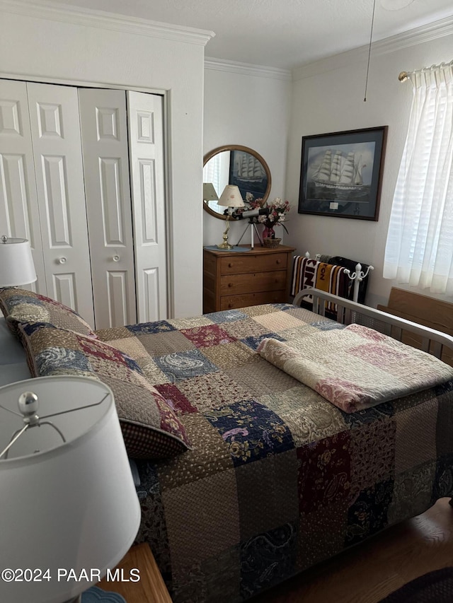 bedroom with dark hardwood / wood-style flooring, ornamental molding, and a closet