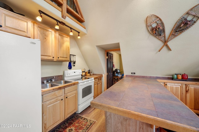 kitchen with light brown cabinets, white appliances, sink, light hardwood / wood-style flooring, and tile counters