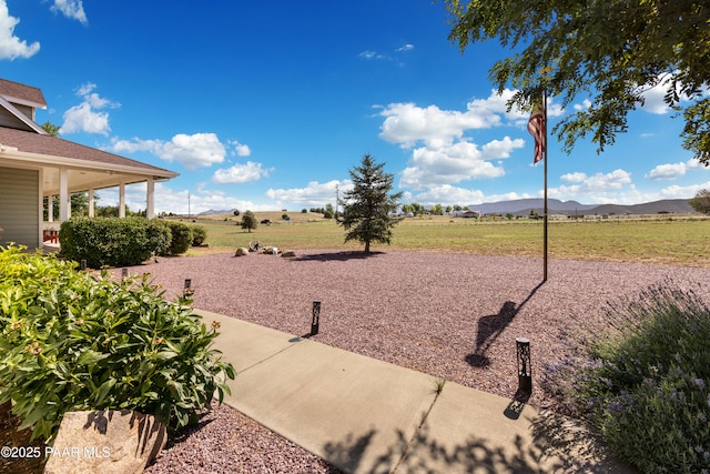 view of yard with a mountain view and a rural view