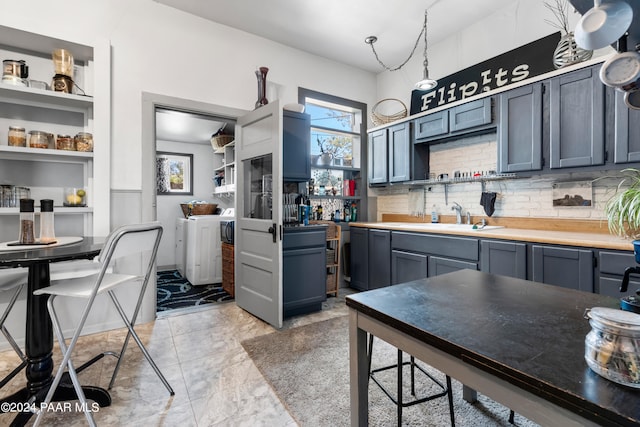 kitchen featuring tasteful backsplash, blue cabinetry, and sink