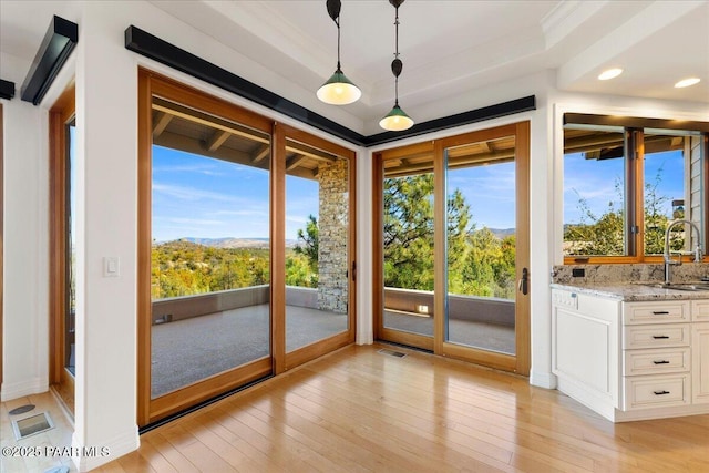 unfurnished sunroom featuring a raised ceiling, visible vents, and a sink