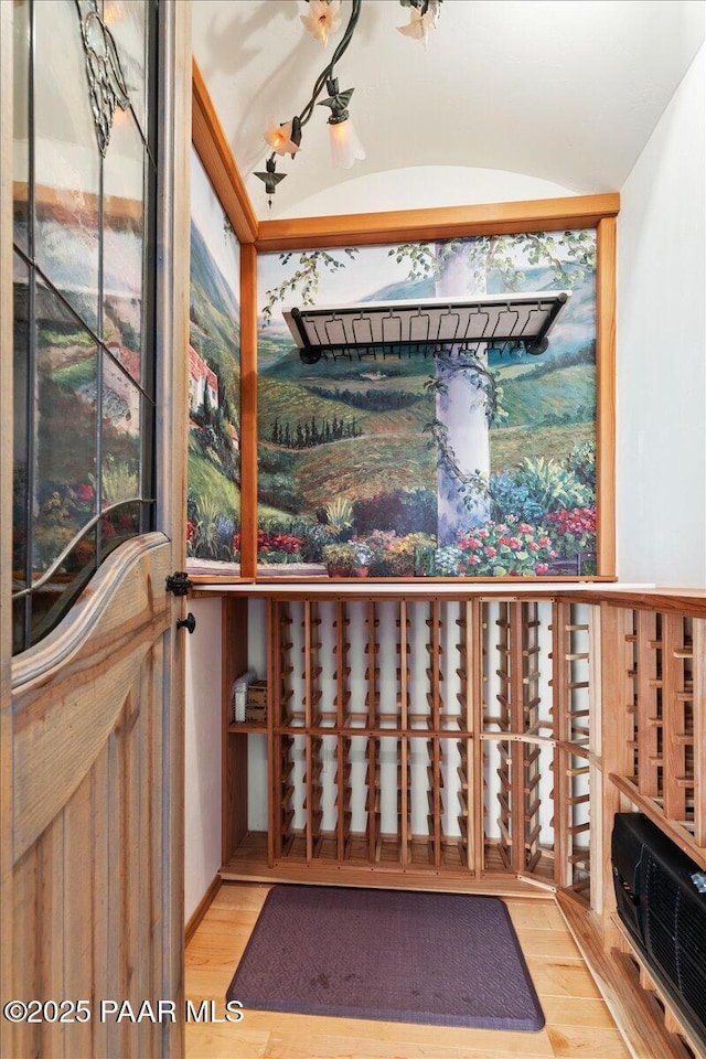 wine area with lofted ceiling and wood finished floors