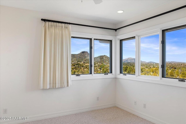 carpeted spare room with recessed lighting, a mountain view, and baseboards