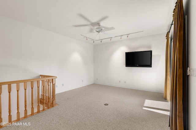 unfurnished room featuring track lighting, baseboards, carpet, and a ceiling fan