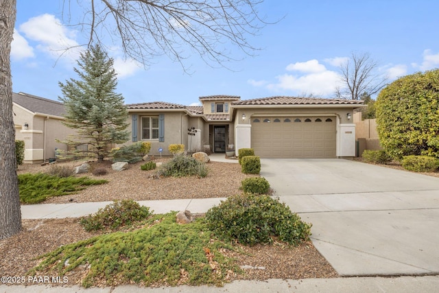 view of front of home with a tile roof, concrete driveway, a garage, and stucco siding