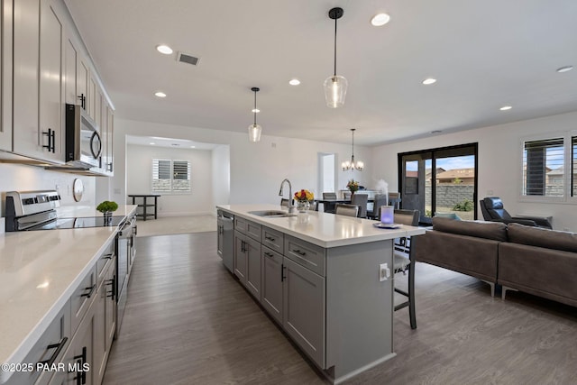 5083 N Kingsley Ct, Prescott Valley, AZ 86314 - kitchen featuring stainless steel appliances, gray cabinets, dark wood finished floors, a kitchen bar, and recessed lighting