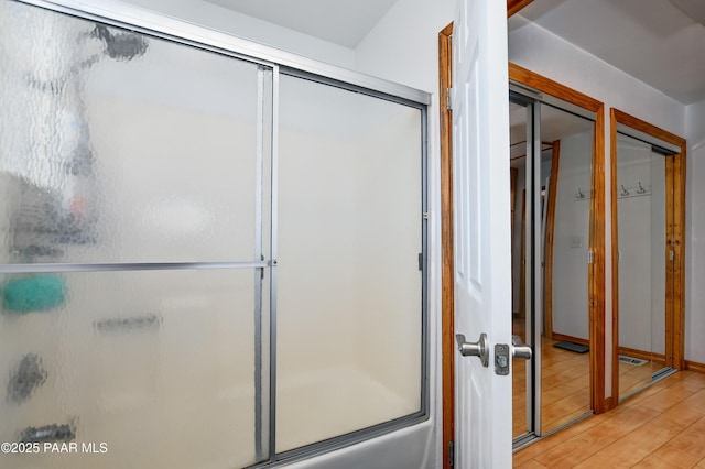 bathroom featuring combined bath / shower with glass door and wood finished floors