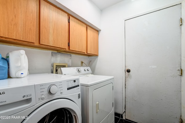 clothes washing area featuring cabinet space and washer and dryer