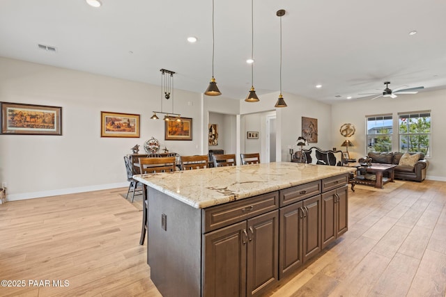 1450 Henry Dr, Chino Valley, AZ 86323 - kitchen with light wood finished floors, a breakfast bar, recessed lighting, light stone countertops, and a ceiling fan
