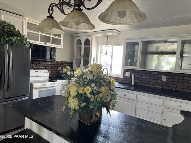2532 Huron St, Dewey-Humboldt, AZ 86329 - kitchen with white range with electric stovetop, black microwave, fridge with ice dispenser, dark countertops, and glass insert cabinets