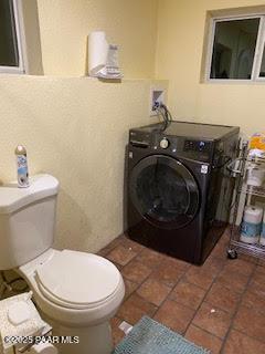 bathroom with washer / clothes dryer, tile patterned floors, and toilet