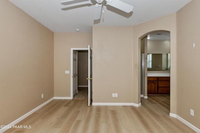 unfurnished bedroom featuring connected bathroom, ceiling fan, and light hardwood / wood-style floors