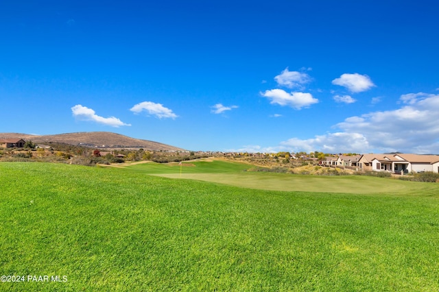 surrounding community featuring a mountain view and a lawn