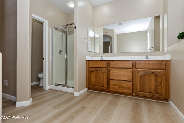 bathroom featuring vanity, an enclosed shower, and hardwood / wood-style flooring