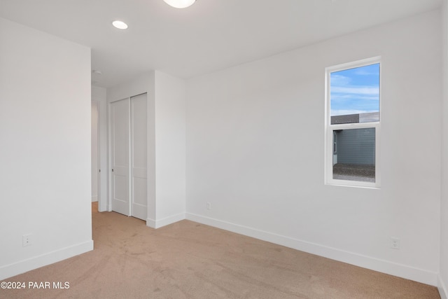 spare room featuring light colored carpet