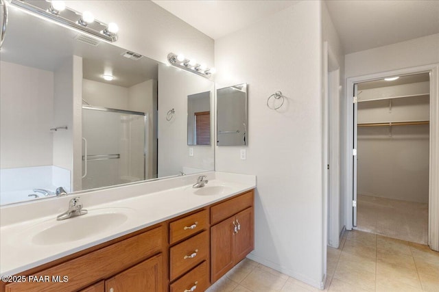 bathroom featuring tile patterned flooring, plus walk in shower, and vanity