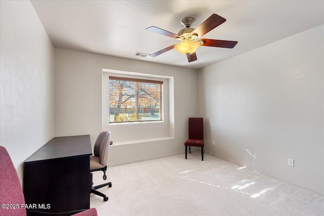 carpeted office space featuring ceiling fan