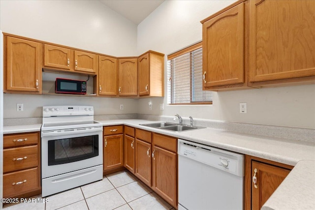 kitchen featuring sink, white appliances, and light tile patterned flooring