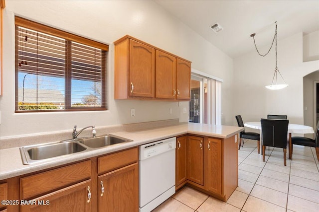 kitchen featuring pendant lighting, sink, lofted ceiling, light tile patterned floors, and white dishwasher