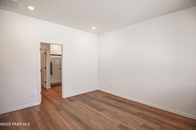 unfurnished room featuring recessed lighting, baseboards, visible vents, and wood finished floors