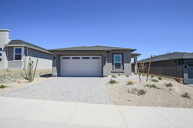 view of front of house featuring an attached garage, decorative driveway, and stucco siding