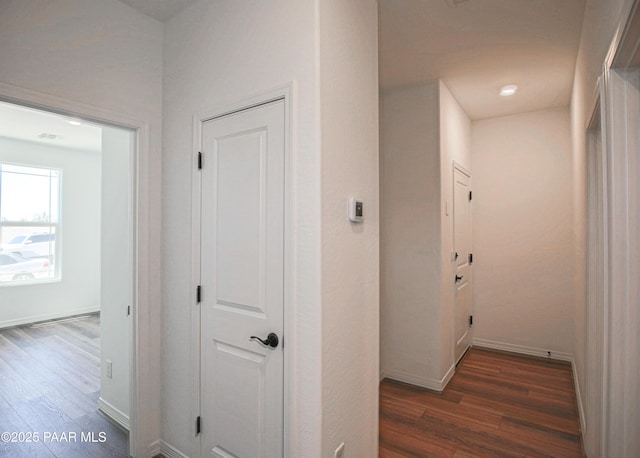 hallway featuring baseboards and wood finished floors
