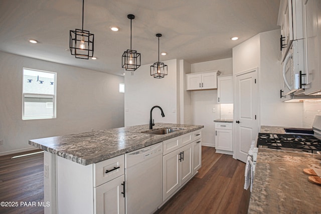 kitchen with a sink, dark wood-style floors, recessed lighting, white appliances, and an island with sink