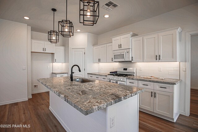 kitchen featuring a sink, white appliances, white cabinetry, baseboards, and dark wood-type flooring