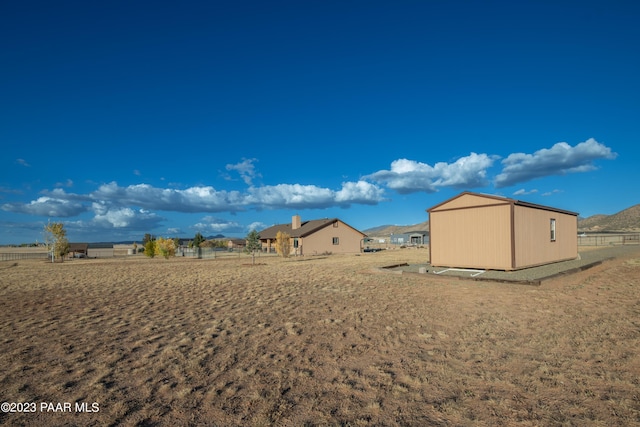 view of yard with a rural view and a shed