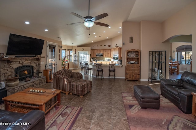 living room with ceiling fan, a fireplace, and high vaulted ceiling