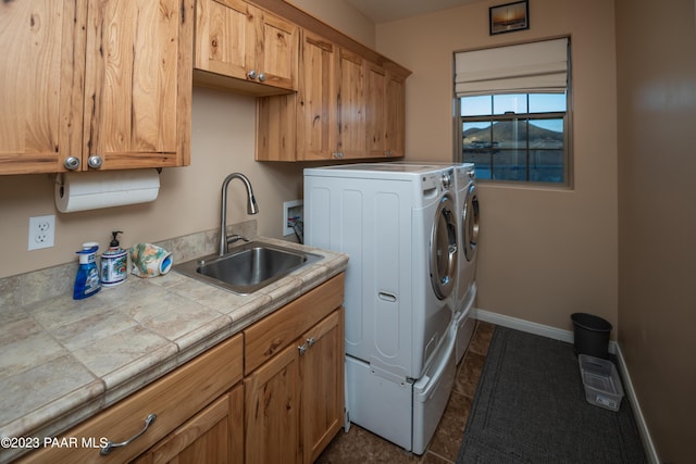 laundry room with separate washer and dryer, sink, and cabinets