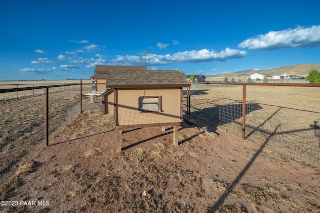 view of home's community with a mountain view, a rural view, and an outdoor structure