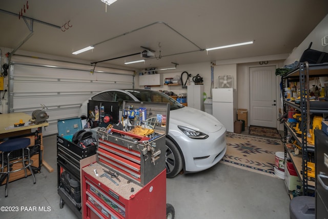 garage with white refrigerator and a garage door opener