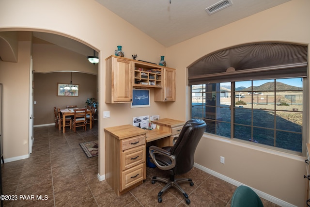 office with dark tile patterned flooring and vaulted ceiling